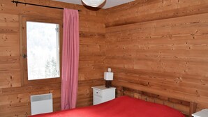 A wooden-paneled room with a bed, a window, and a nightstand. - Cozy apartment with south balcony in Bozel (Bozel)