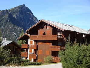 Un chalet en bois doté de plusieurs balcons, situé dans un cadre montagneux.