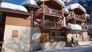 A wooden chalet with multiple balconies and a mountain backdrop. - Pleasant 3-room apartment with garden, close to the center (Pralognan-la-Vanoise)