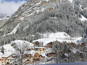 Una montagna innevata con un gruppo di chalet di legno.