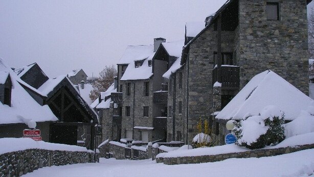 A snow-covered village with stone buildings and a stone wall. - Duplex T4 for 7 with terrace and parking in Esquièze-Sère (Esquièze-Sère)