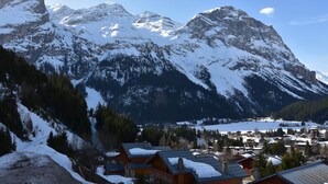 A mountain town with snow-covered peaks and a lake in the valley. - Cozy studio near slopes, quiet with closed garage (Pralognan-la-Vanoise)