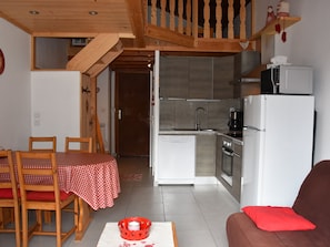 A compact living space with a dining area, kitchenette, and a sofa. - Loft studio in Champagny, 4 pax, south-facing balcony (Champagny-en-Vanoise)