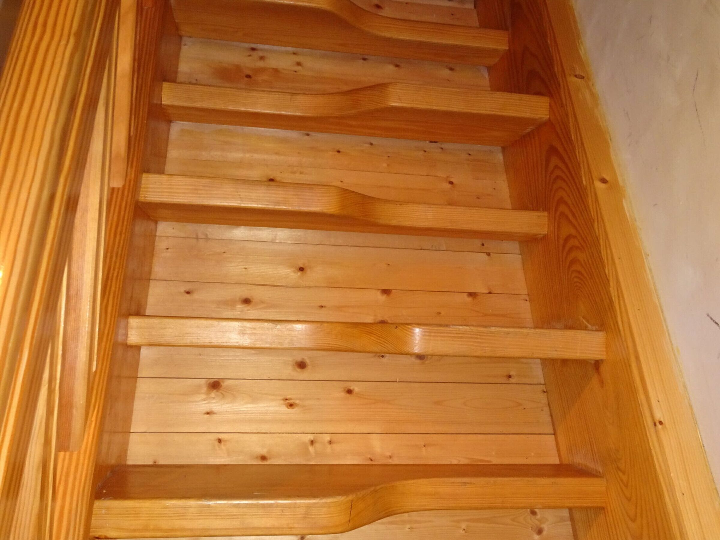 A wooden staircase with a handrail and steps.