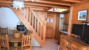 A wooden interior with a dining area, kitchen, and a staircase leading to another room. - 4-room Duplex with balcony and parking in Pralognan, near slopes (Pralognan-la-Vanoise)