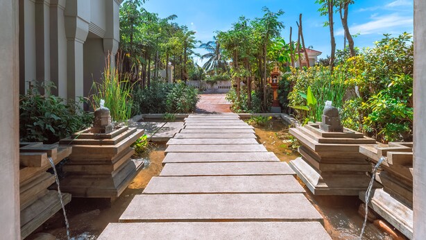 A pathway leading to a traditional temple with a water feature. - Cheata Residence (Siem Reap)