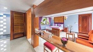 A hotel room with a bed, a wooden desk, a chair, a nightstand, and a view of the outside. - Cheata Residence (Siem Reap)
