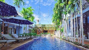 A swimming pool with lounge chairs and palm trees. - Cheata Residence (Siem Reap)