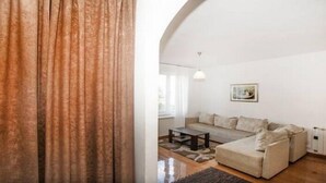 A living room with a sofa, a coffee table, and a rug. - Apartment Rubin (Belgrade)