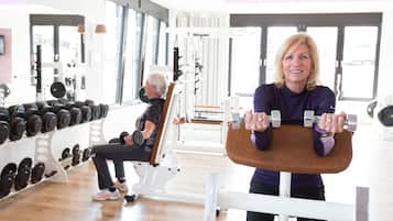 A gym with exercise equipment, including dumbbells and a bench.