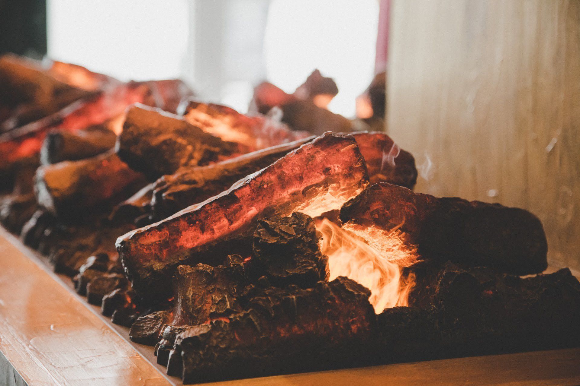A row of glowing coals in a fireplace.