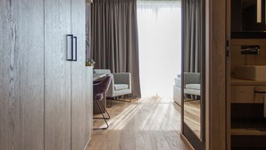 Una sala de estar moderna con suelo de madera, dos sofás grises, una mesita y una silla morada.