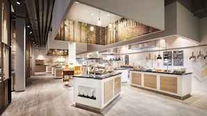 A modern kitchen with high ceilings, wooden flooring, and a central island with a sink and counter space. - aja Ruhpolding (Ruhpolding)