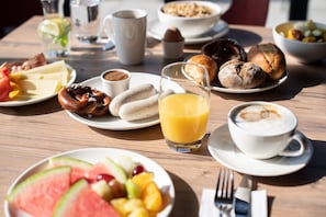 A breakfast table with various food items and beverages.