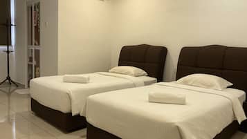 Habitación de hotel con dos camas, cada una con cabecera marrón y ropa de cama blanca.