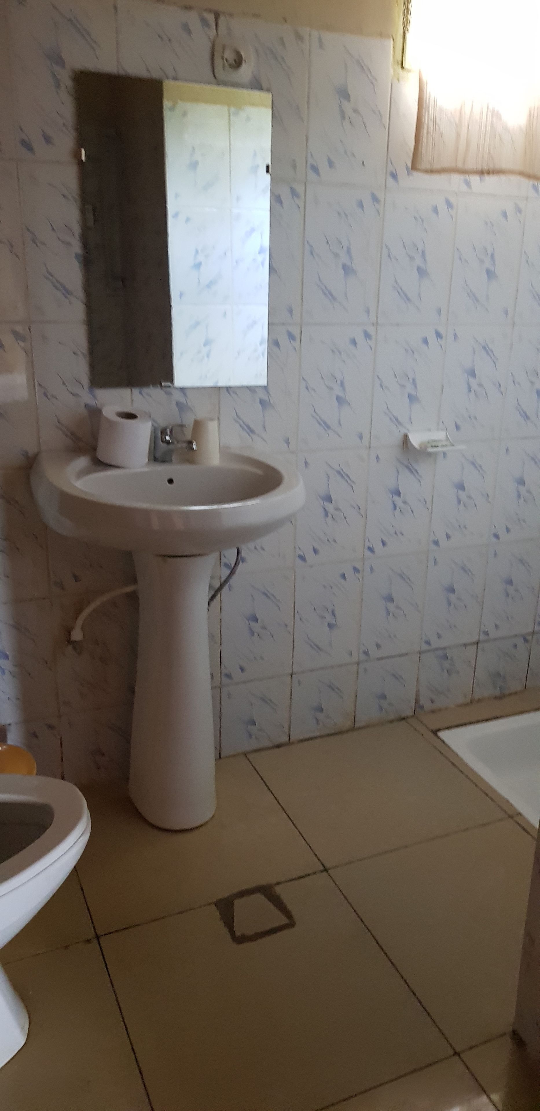 Un baño con lavamanos, espejo, inodoro y bañera.