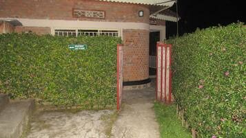 A brick building with a tiled roof, a gated entrance, and a sign indicating an apartment.
