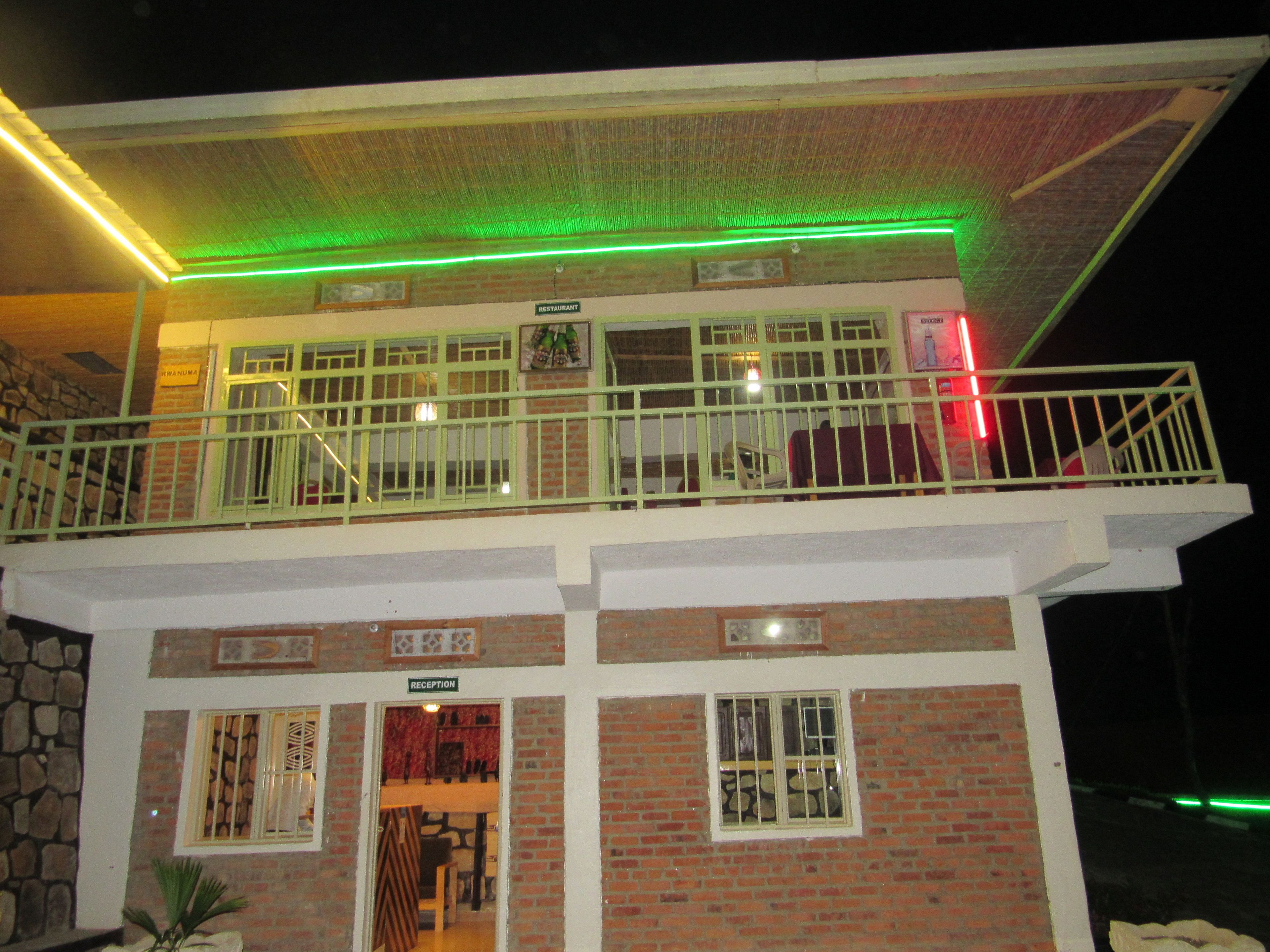 Un edificio a due piani con una reception al piano terra e un ristorante al piano superiore.