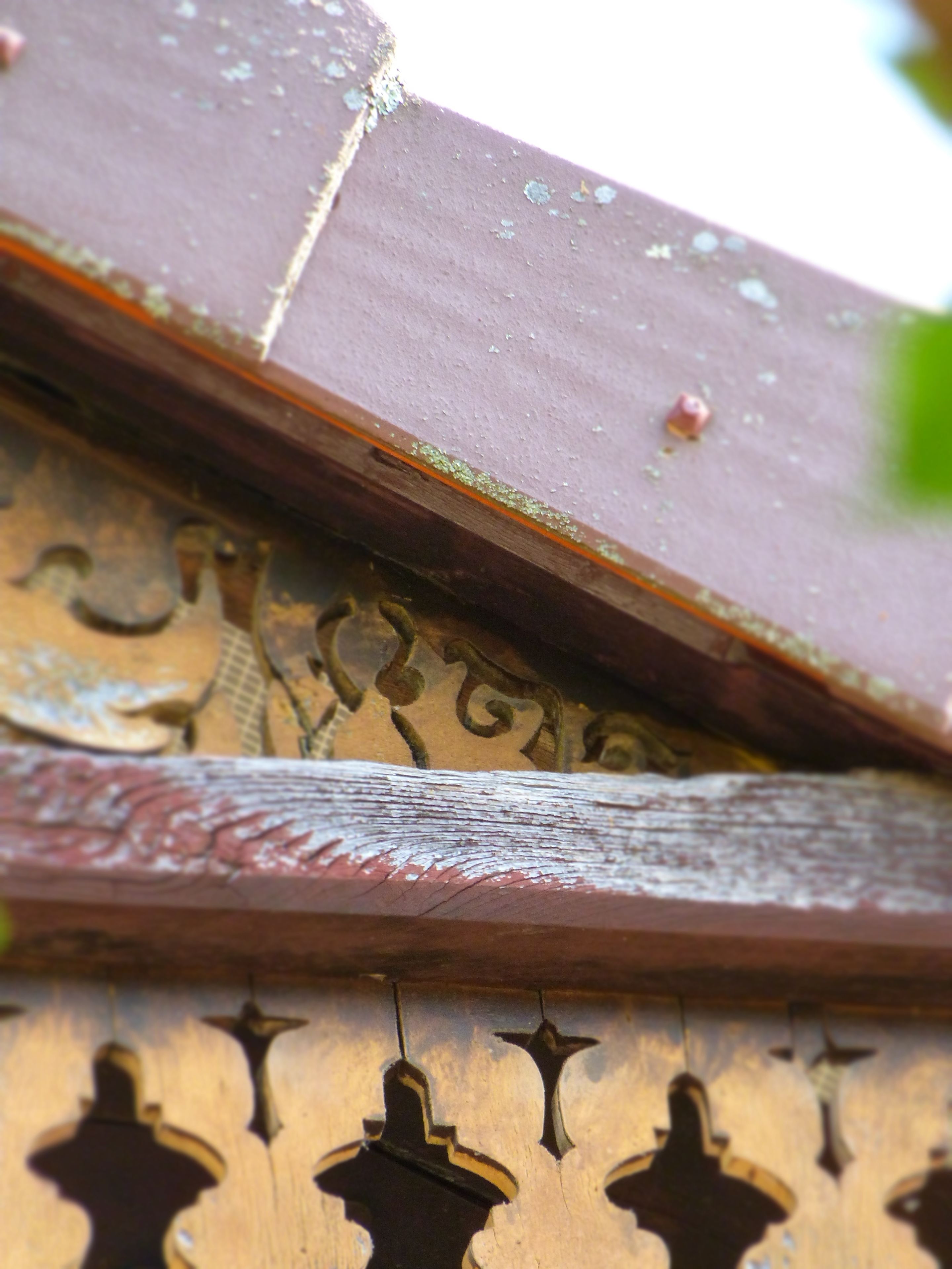 A close-up of a wooden structure with intricate carvings and a weathered surface.