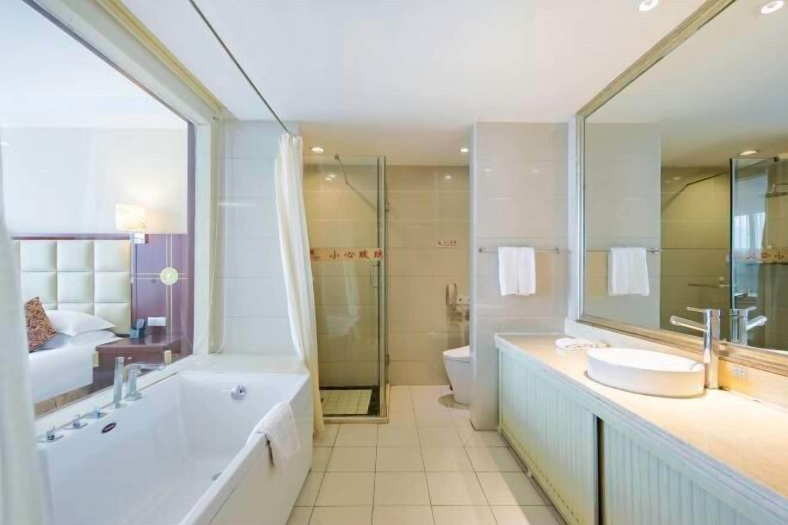 A modern bathroom with a bathtub, a shower, and a toilet.