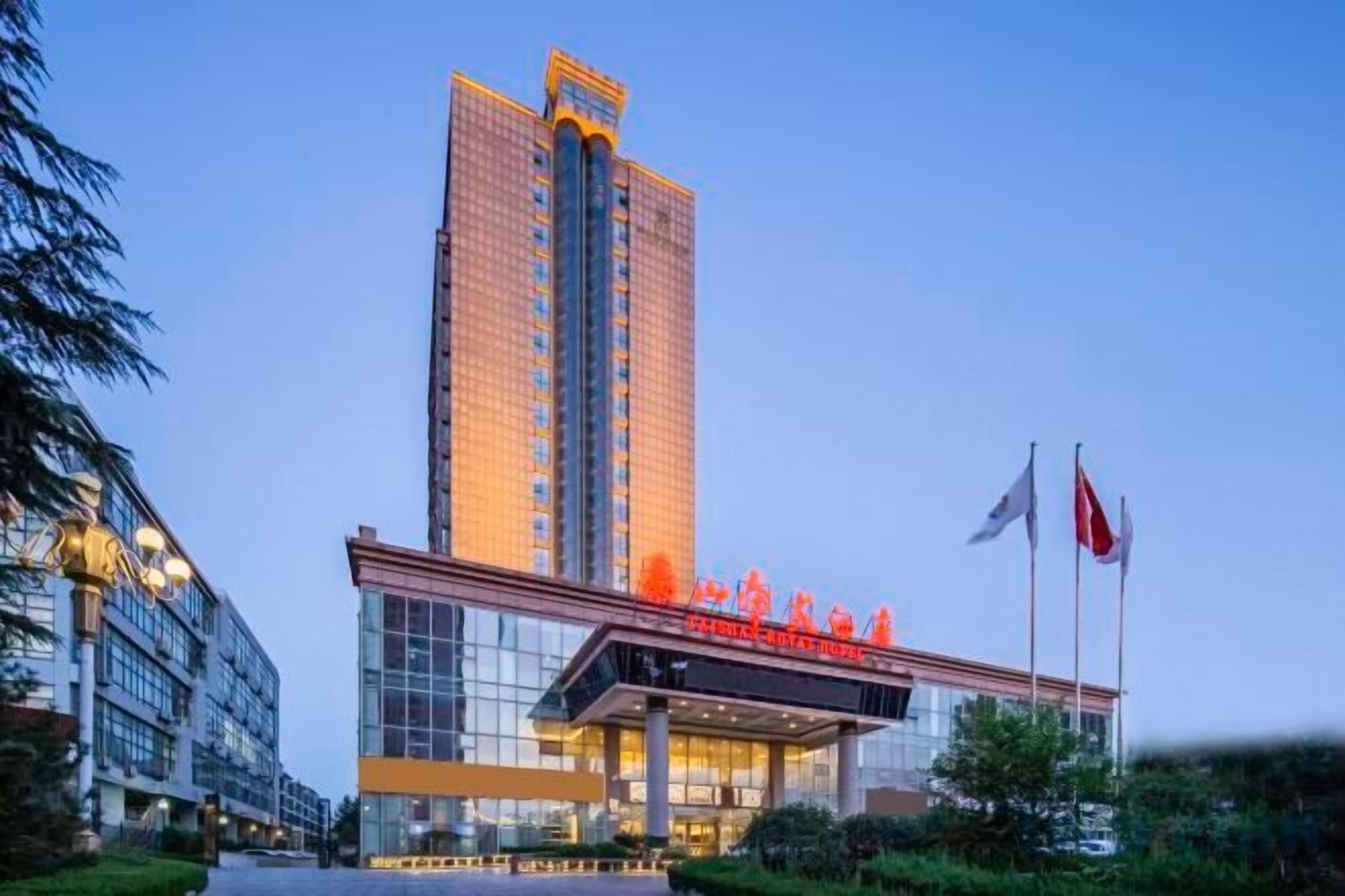 Un hotel moderno de gran altura con una entrada destacada y varias banderas.