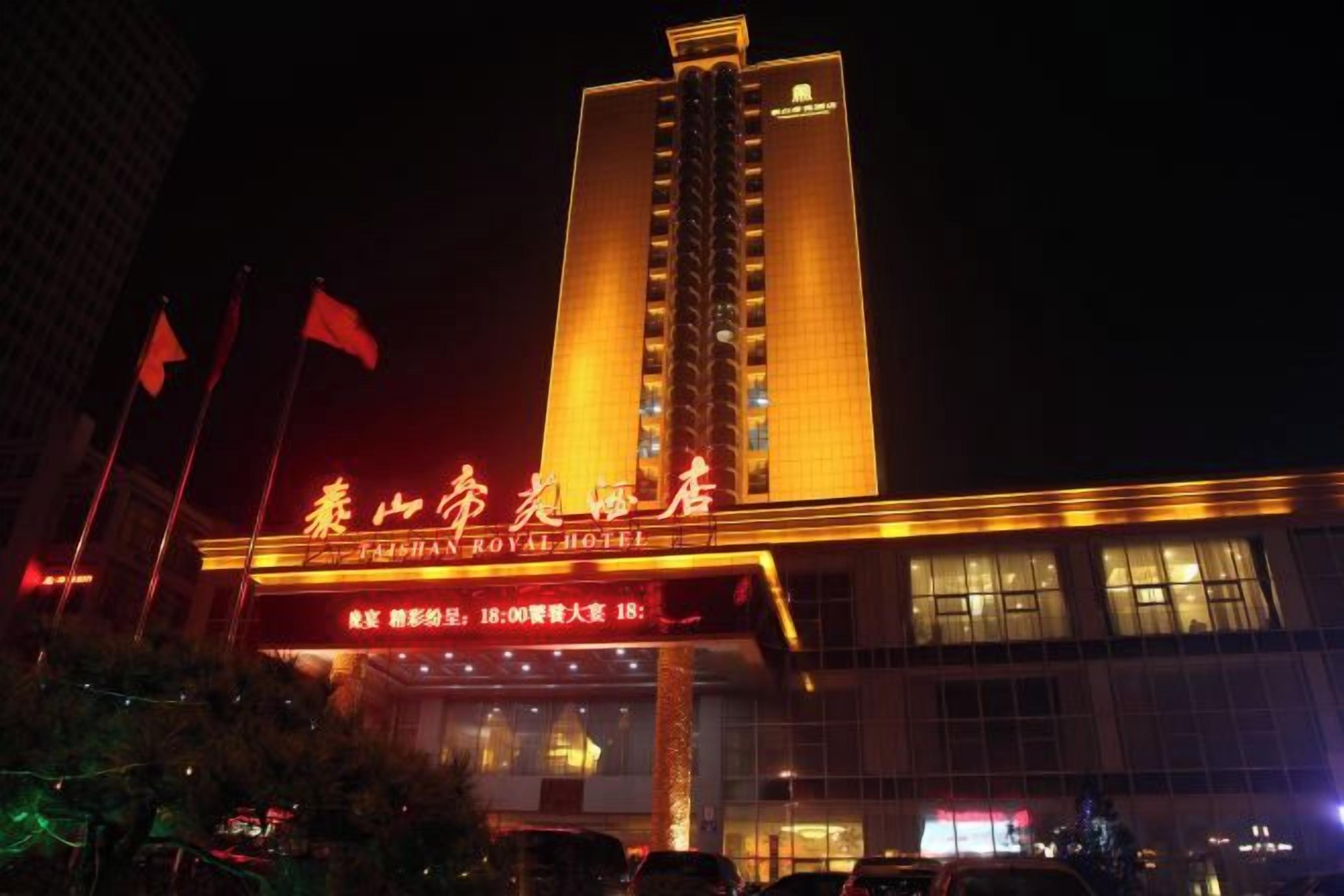 A hotel with a prominent vertical structure and illuminated signage.