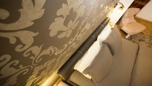 A close-up of a patterned wall with a partially visible door and a chair. - Apartment Mozaik (Belgrade)