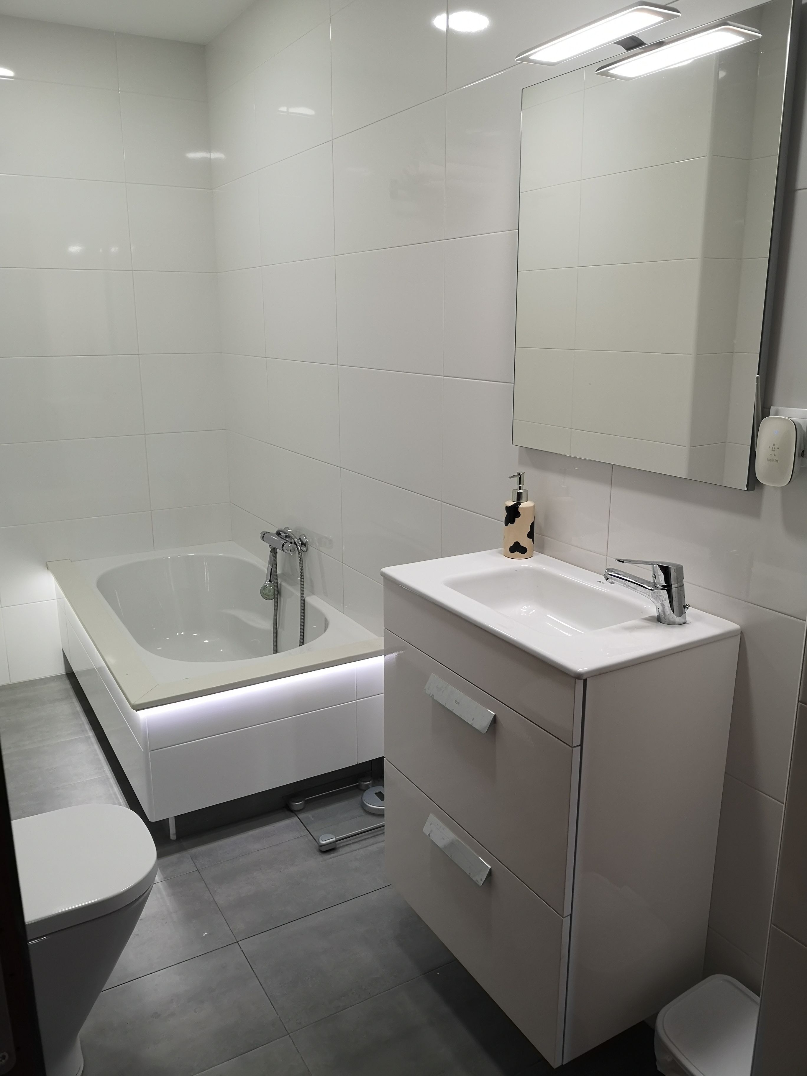A modern bathroom with a bathtub, a sink, and a toilet.
