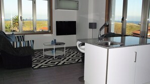 Una cocina moderna con un amplio ventanal, un comedor con un tapete de diseño blanco y negro, y vistas al paisaje.