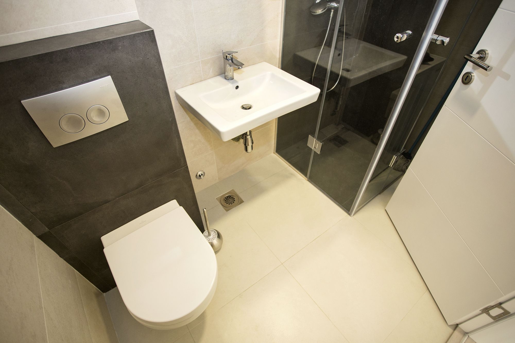 Une salle de bain avec des toilettes, un lavabo et une douche.