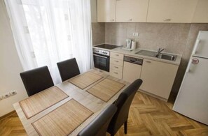 Apartamento, 3 quartos | Cozinha privada | Geladeira, micro-ondas, fogão, cooktop