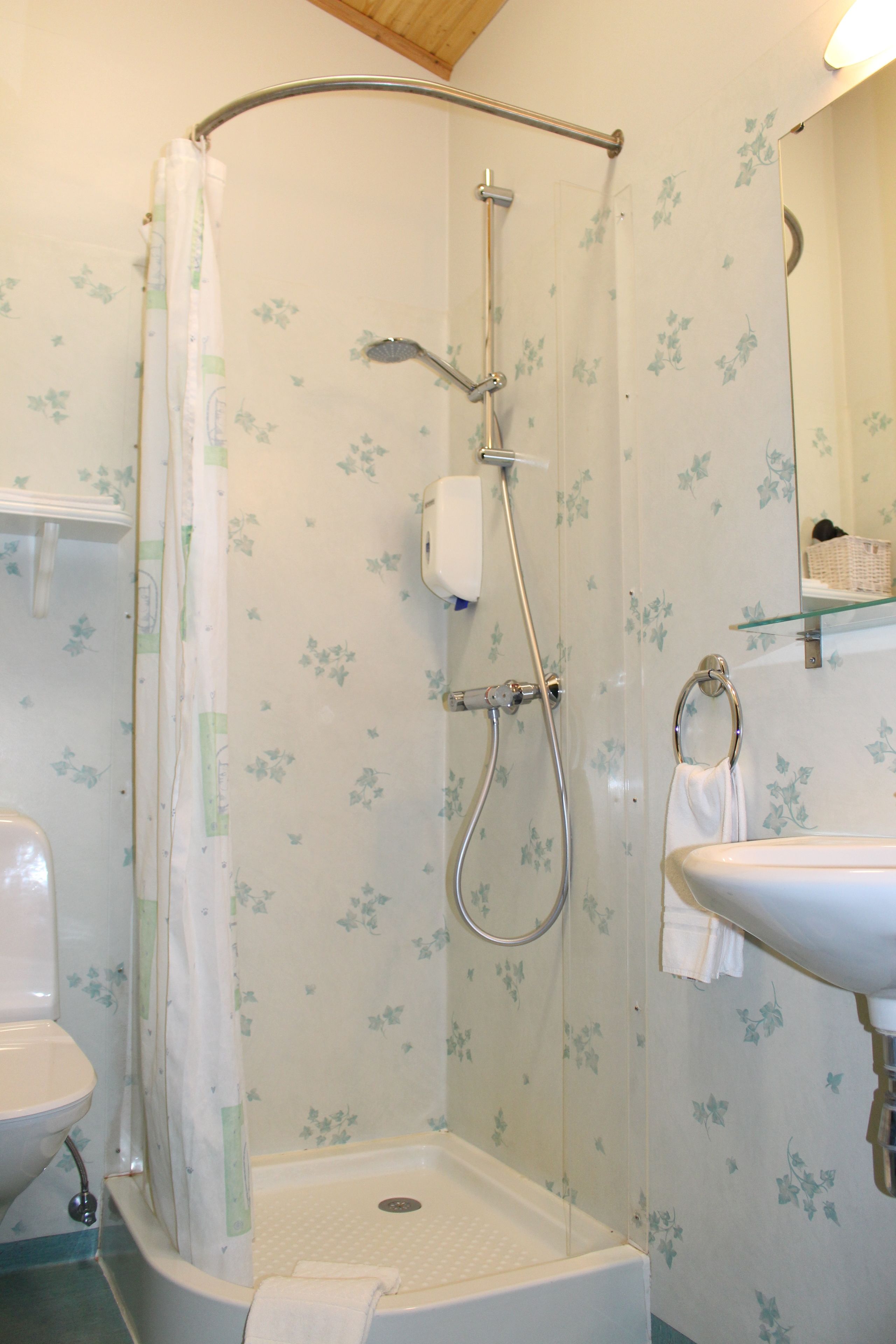 A bathroom with a shower, toilet, and sink.