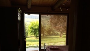 A bedroom with a large window, a bed, and a view of a garden. - Residence delle Rose (Monforte d'Alba)