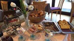 A buffet table with various food items including pastries, bread, and condiments. - Hotel Garni Fuchs (Eichstaett)