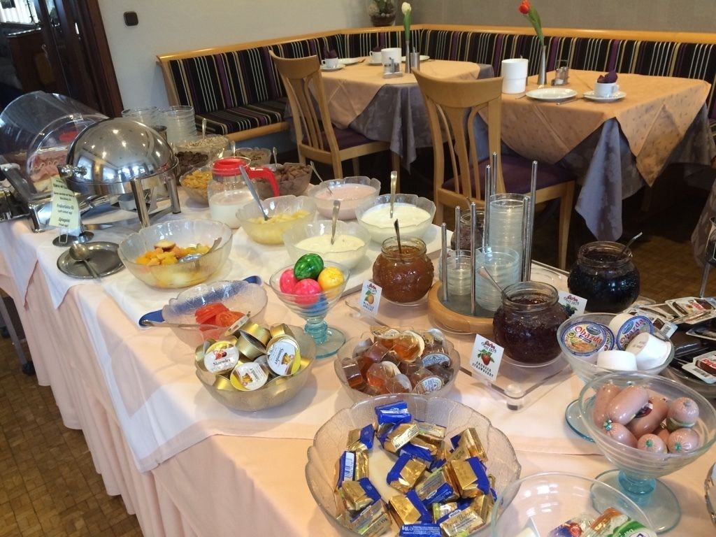 A buffet table with various food items and condiments.