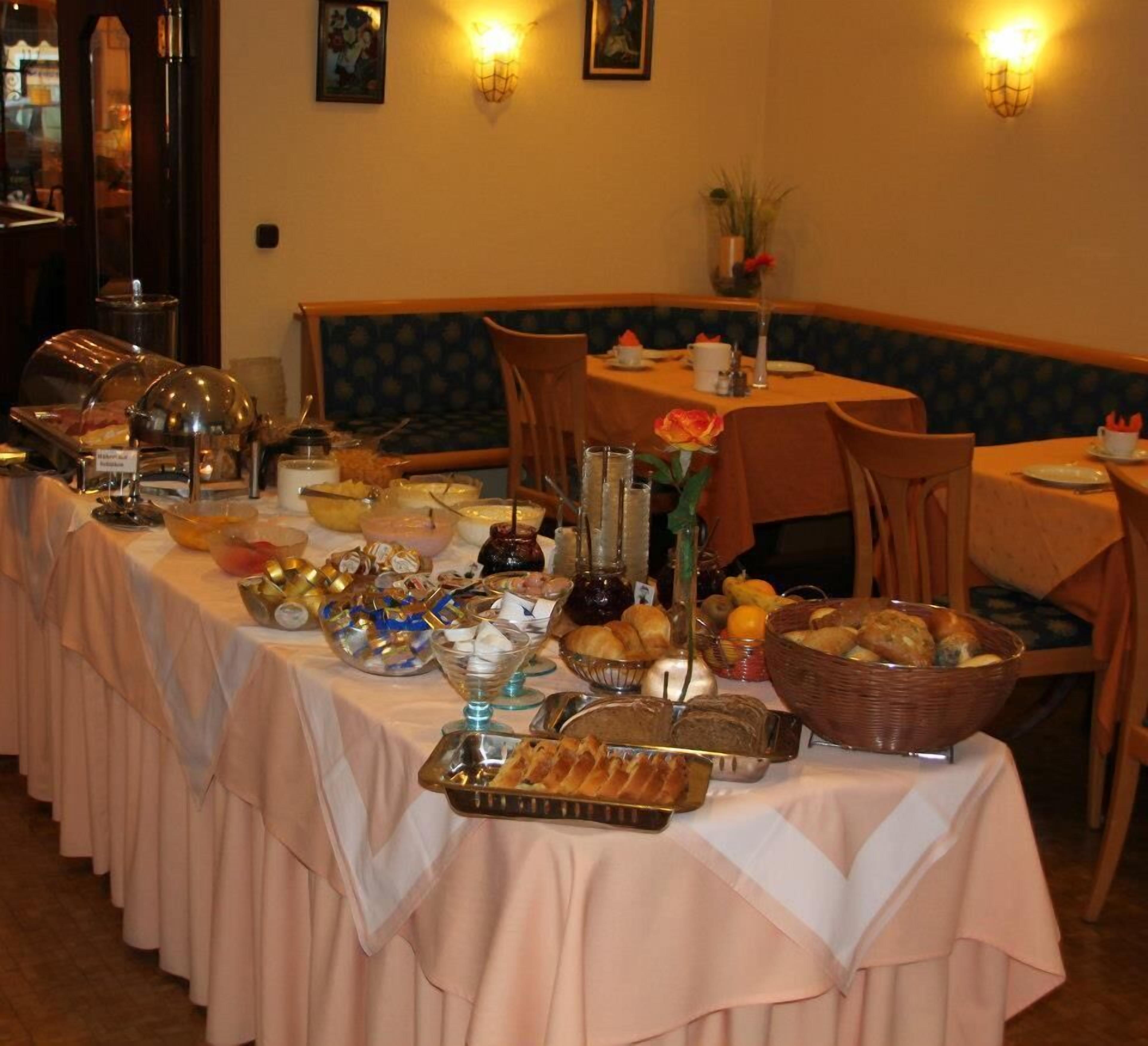 Een buffetopstelling met diverse gerechten en een zithoek met tafels en stoelen.