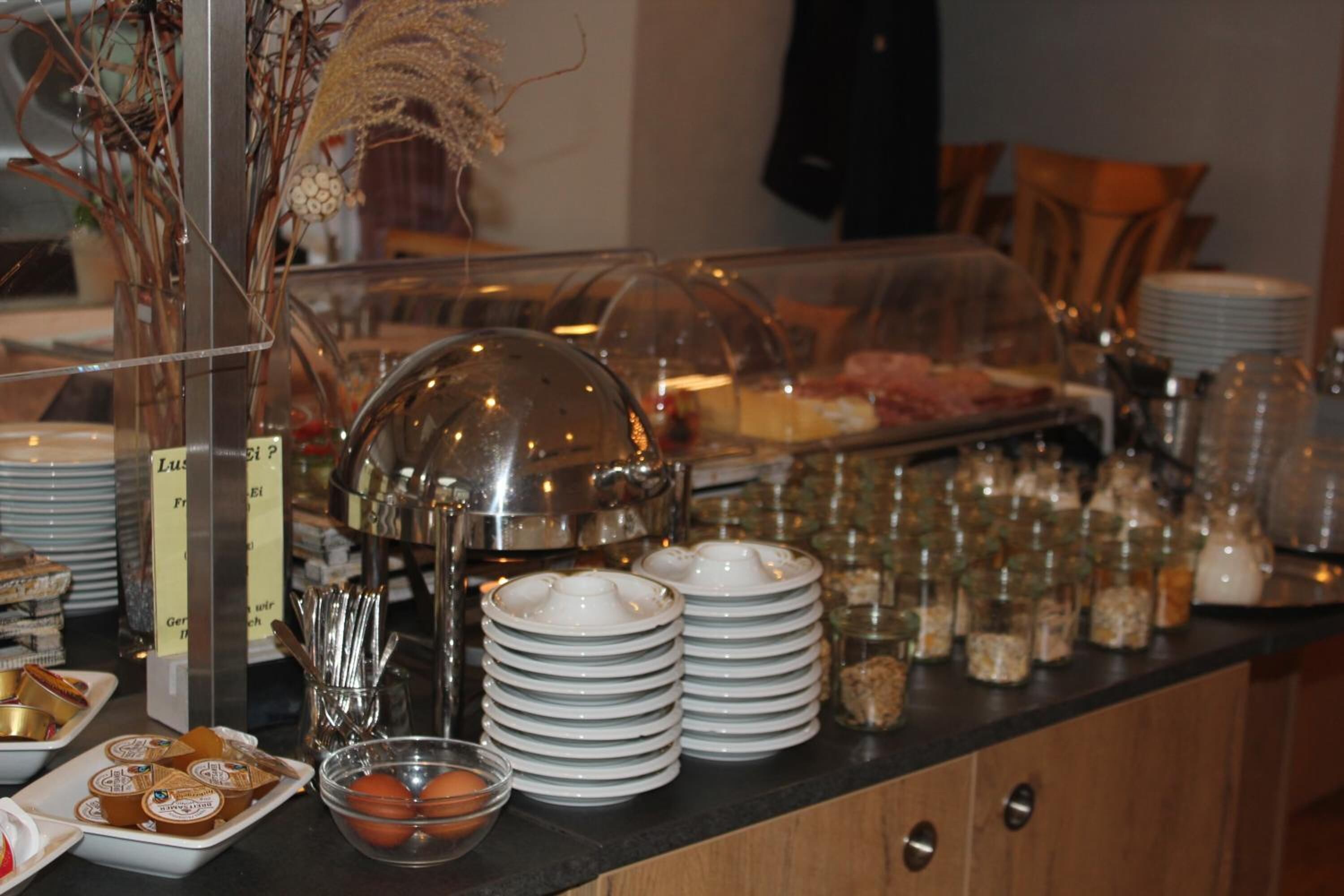 A buffet setup with various food items, plates, and serving utensils.