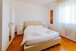 A neatly arranged bedroom with a bed, bedside tables, a wardrobe, and a painting on the wall. - Welc-oM Manuela (Selvazzano Dentro)