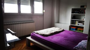 Une chambre à coucher avec un lit, un bureau et une bibliothèque.
