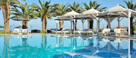 Una piscina al aire libre, sillones reclinables de piscina