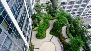Un immeuble de grande hauteur doté d’un jardin sur le toit, agrémenté de sentiers sinueux et d’une végétation luxuriante.