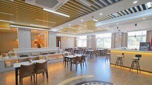 Um saguão de hotel moderno com área de estar central, balcão de recepção e design de piso estampado.