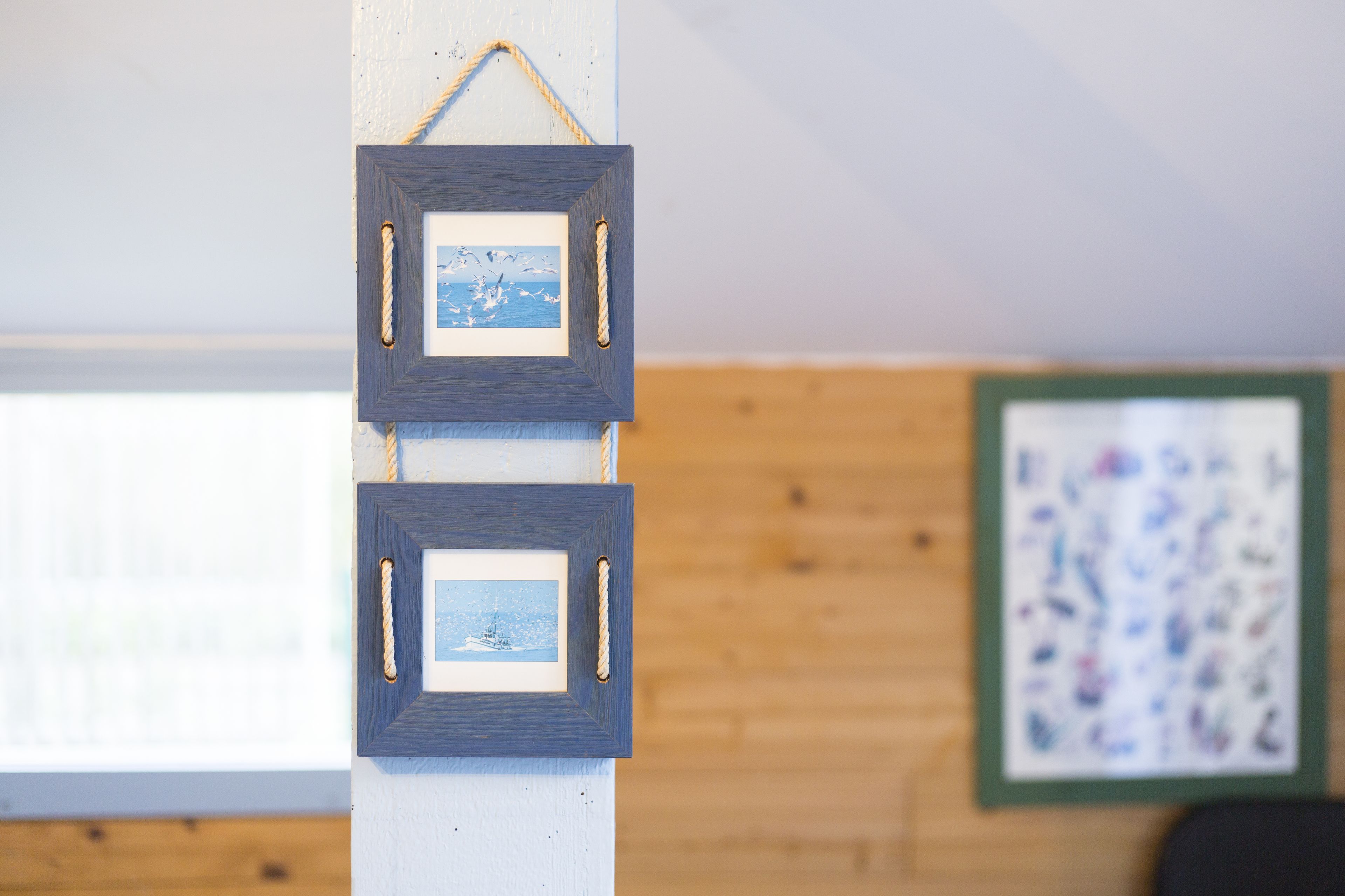 Two framed pictures hanging on a wall, one with a snowy landscape and the other with a colorful abstract pattern.