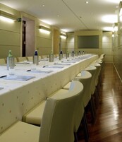 A conference room with a long table, chairs, and water bottles.