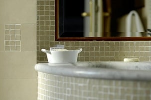 A bathroom with a tiled backsplash, a white sink, and a mirror above it.