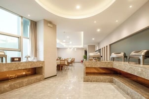 Un moderno vestíbulo de hotel con mostrador de recepción, zona de estar y bufé.