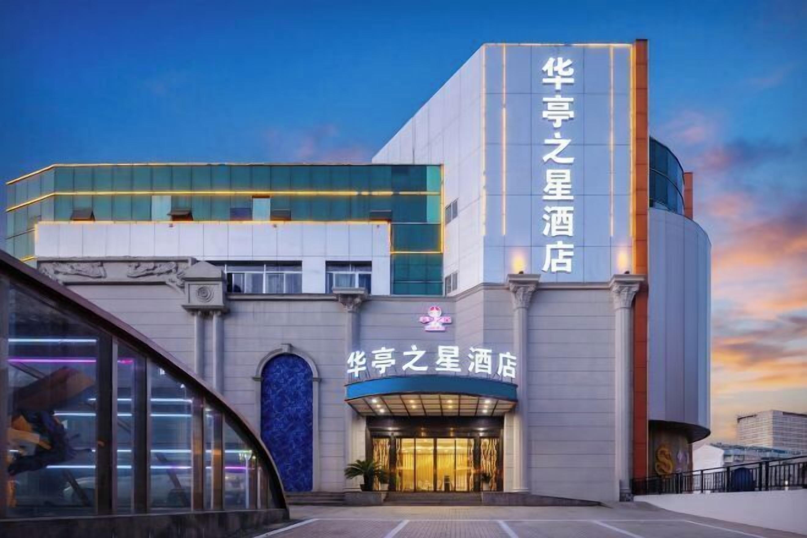 Un hotel con fachada moderna, que presenta una entrada destacada con un letrero en caracteres chinos.