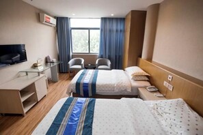 A hotel room with two beds, a desk, a chair, a TV, and a window with curtains. - Huating Business Hotel (Tongling)