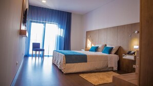 A modern hotel room with a large bed, a desk, and a chair. - Belmonte Sinai Hotel (Belmonte)