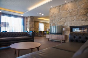 Relax in this stylish living room with a comfortable sofa, flat-screen TV, and dining area.